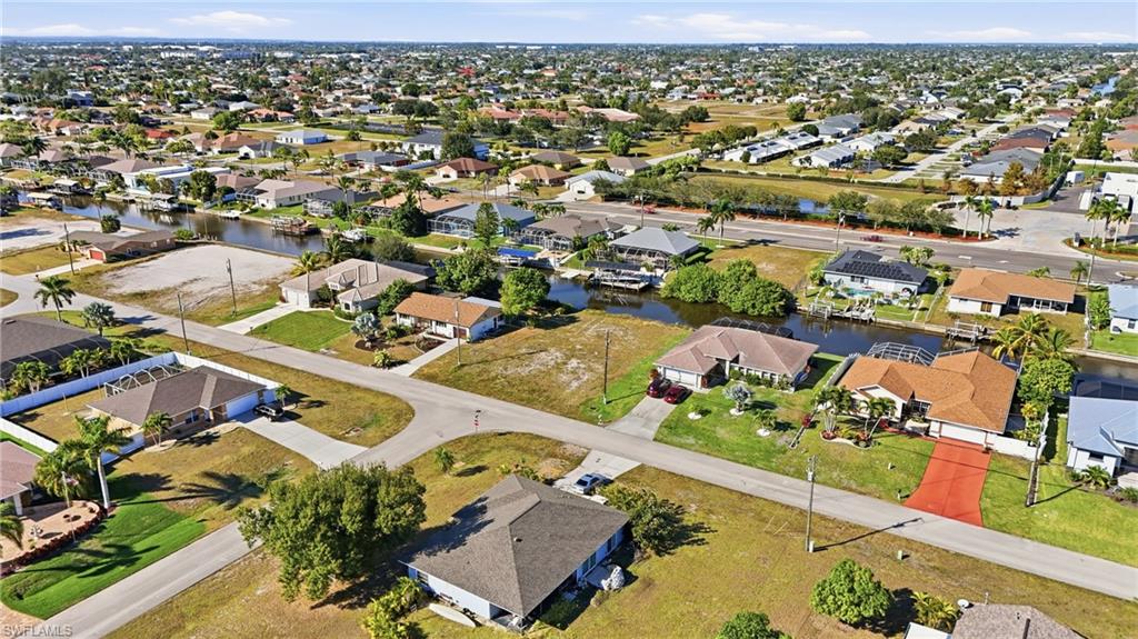 Aerial view of property and surrounding area with nearby suburban area and a nearby body of water