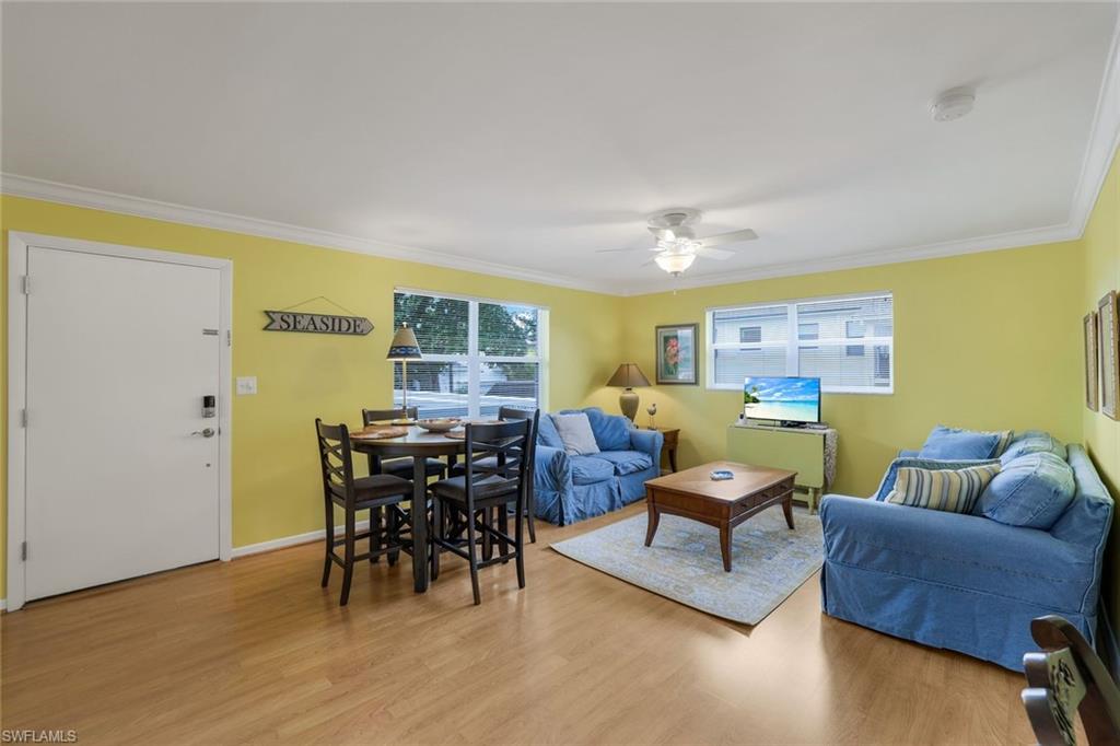 Living room featuring light hardwood / wood-style flooring, crown molding, and plenty of natural light