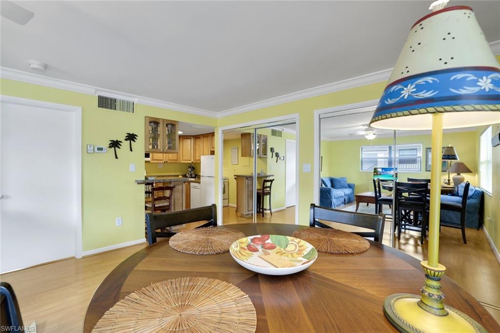 Dining area with crown molding and light wood-type flooring