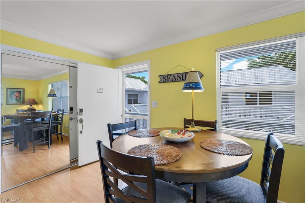 Dining space featuring ornamental molding, plenty of natural light, and light wood-type flooring