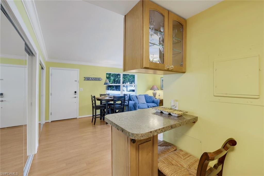 Kitchen featuring crown molding, light hardwood / wood-style floors, kitchen peninsula, and electric panel