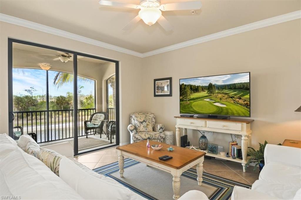 Living room with ceiling fan, crown molding, and tile patterned flooring