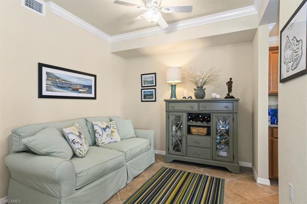 Living area with crown molding, ceiling fan, and light tile patterned flooring