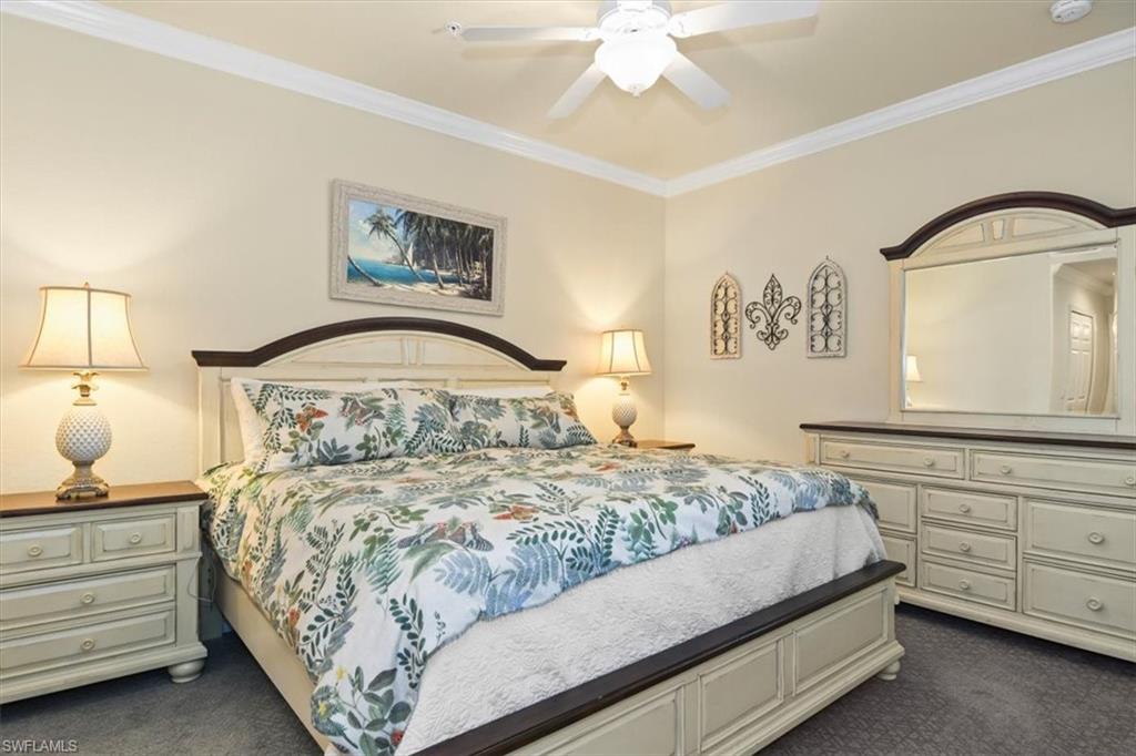 Bedroom with crown molding, dark carpet, and ceiling fan