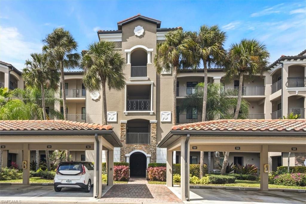 View of apartment building / complex with covered parking