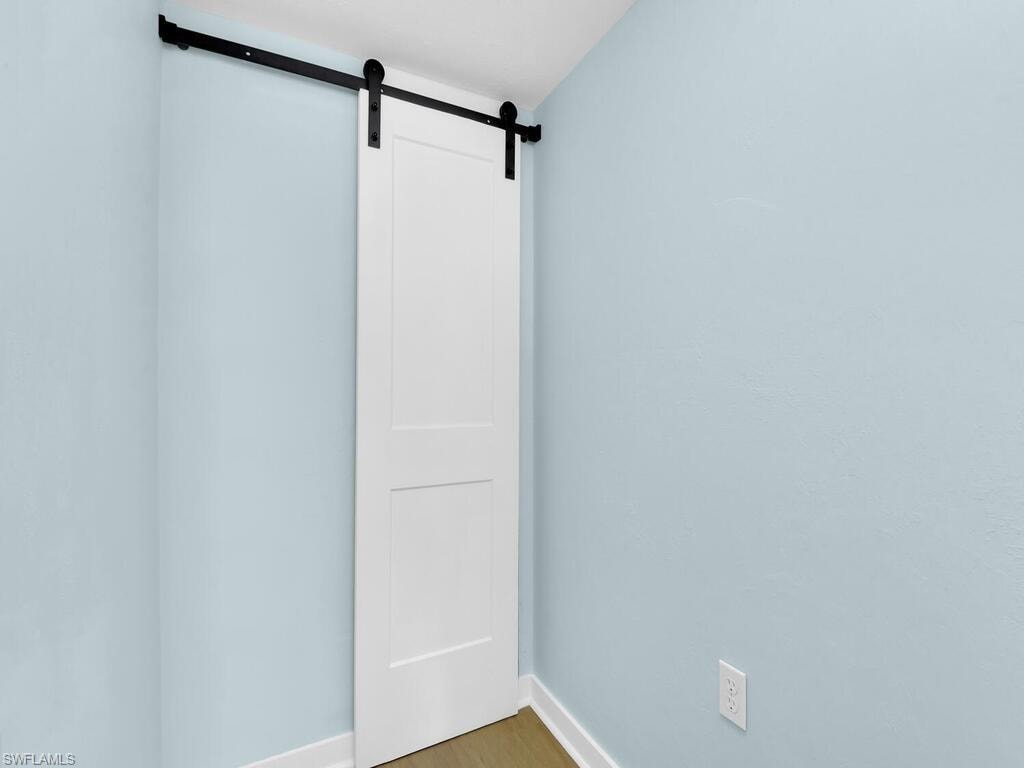 Empty room with a barn door and wood finished floors