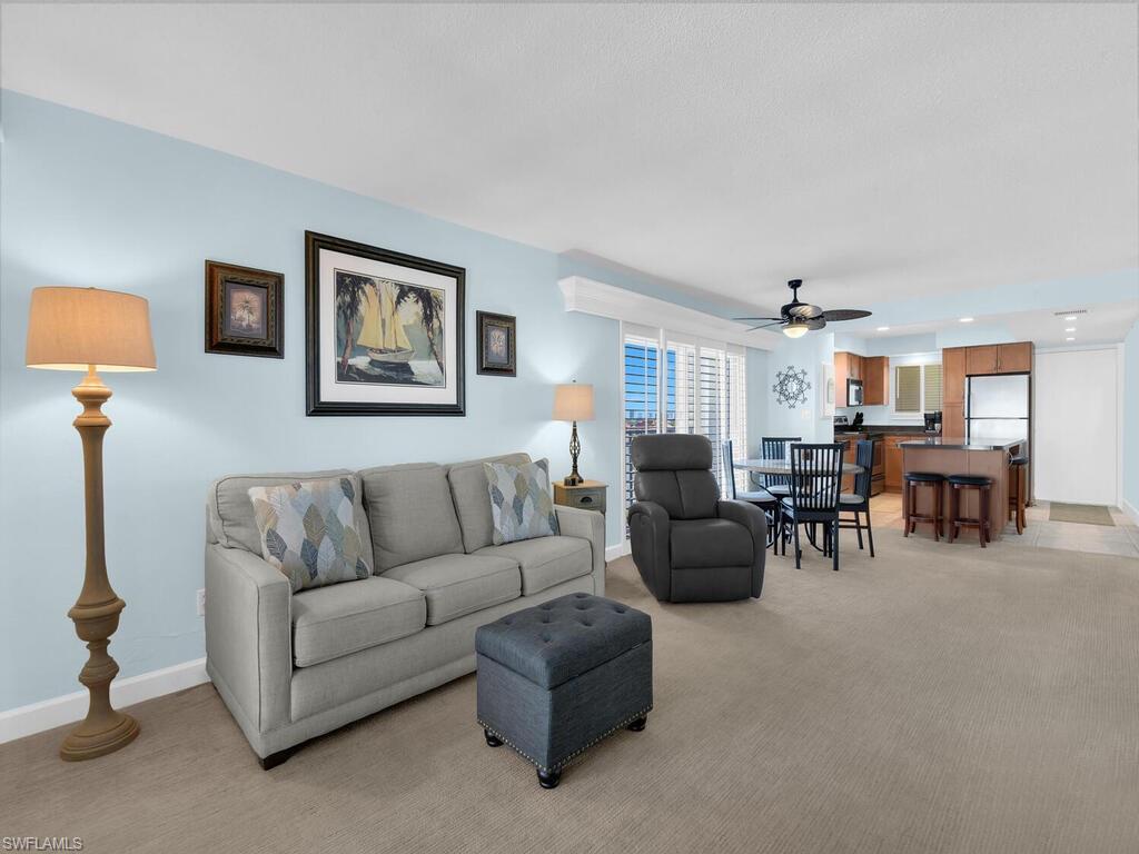 Living room with a ceiling fan, light colored carpet, and recessed lighting