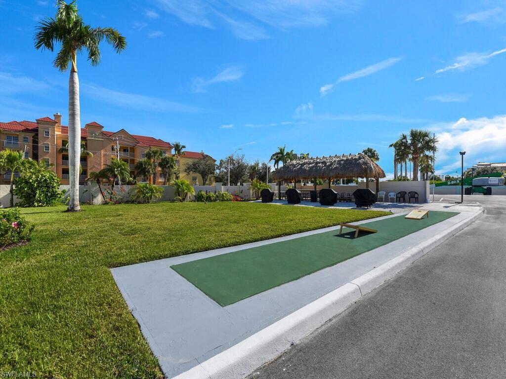 View of home's community featuring a lawn, a patio area, and a game area