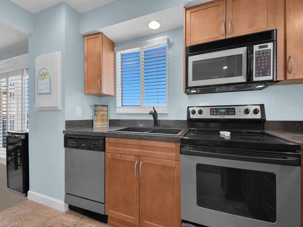 Kitchen with appliances with stainless steel finishes and brown cabinets
