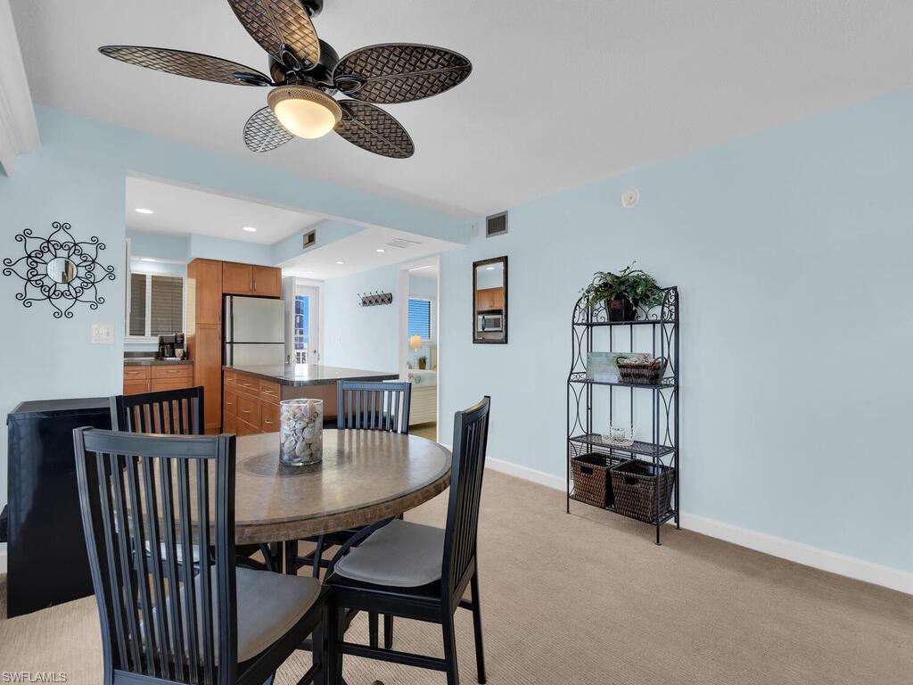 Dining area with light carpet, a ceiling fan, and recessed lighting
