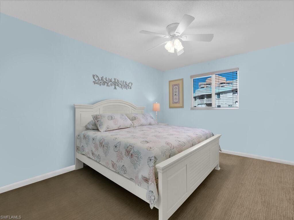 Carpeted bedroom featuring baseboards and ceiling fan