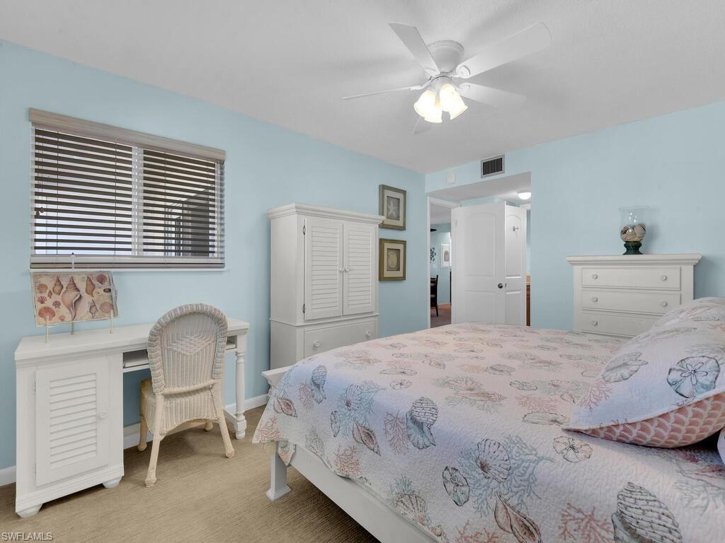 Carpeted bedroom with ceiling fan and an office area