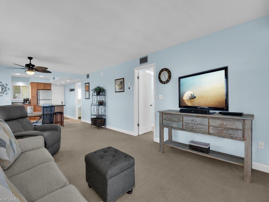 Carpeted living area with baseboards and a ceiling fan