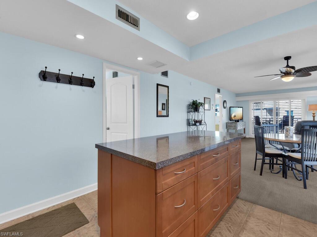 Kitchen featuring brown cabinetry, recessed lighting, a kitchen island, open floor plan, and a ceiling fan