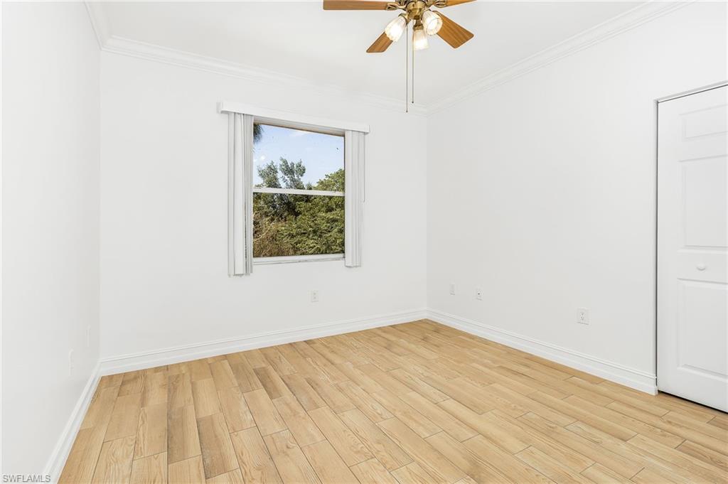 Unfurnished bedroom with light wood-style tile flooring, crown molding, and ceiling fan