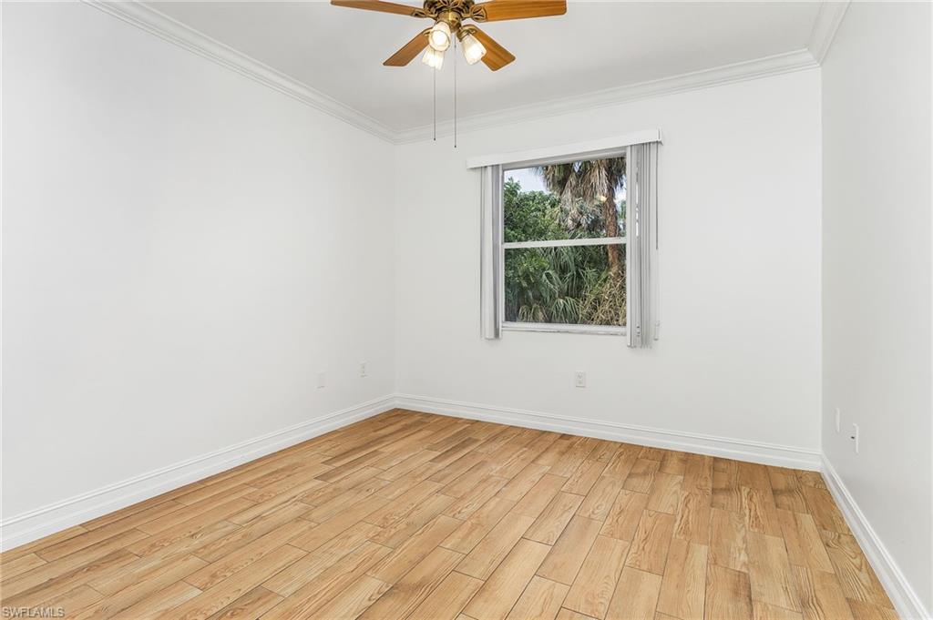 Unfurnished bedroom with light wood-style tile flooring, crown molding, and ceiling fan