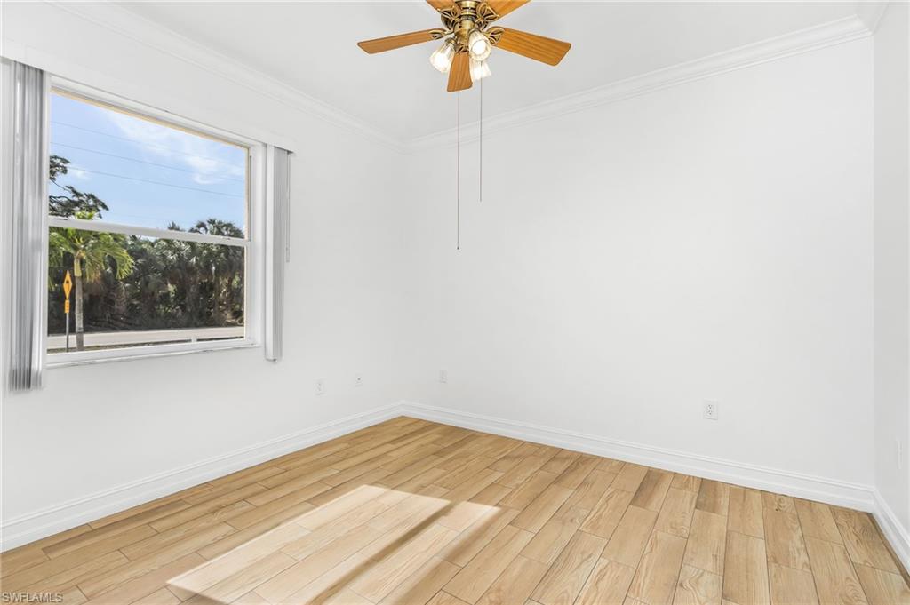Unfurnished bedroom with light wood-style tile flooring, crown molding, and ceiling fan