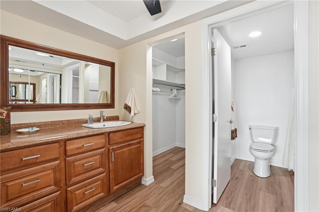 Primary bathroom featuring a spacious walk in closet & large vanity - Virtually Edited Image