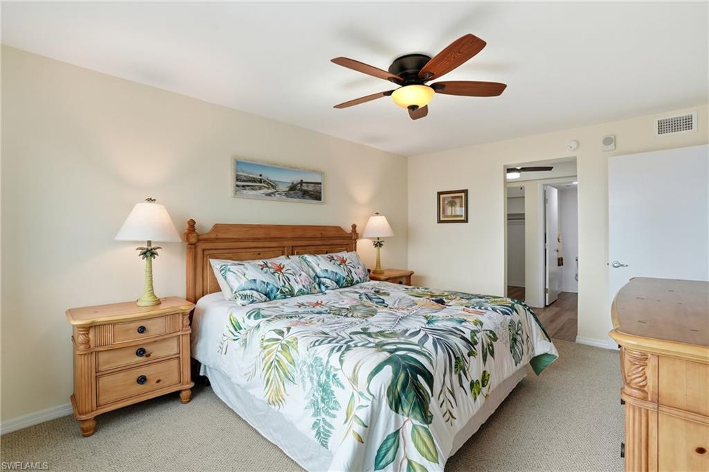 Carpeted bedroom featuring a ceiling fan and a walk in closet - Virtually Edited Image