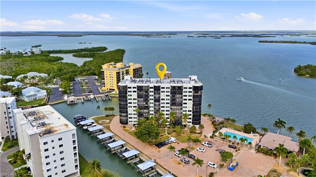 Aerial view of Estero Bay with Boat Docks/lifts on canal, pool & clubhouse on the right- Virtually Edited Image