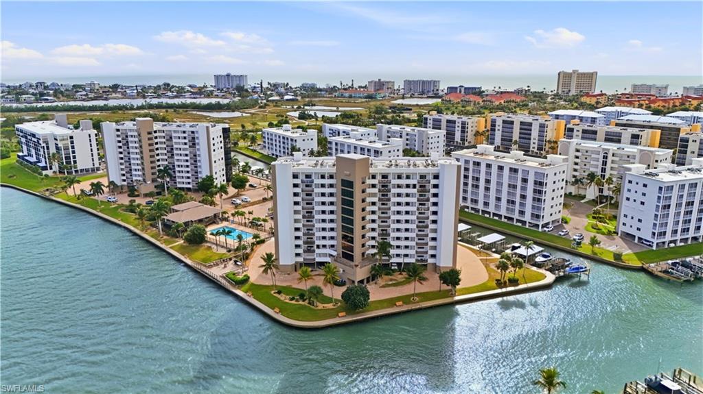 View of Harbour Pointe with pool to the left and the canal with Boat Docks to the right  - Virtually Edited Image
