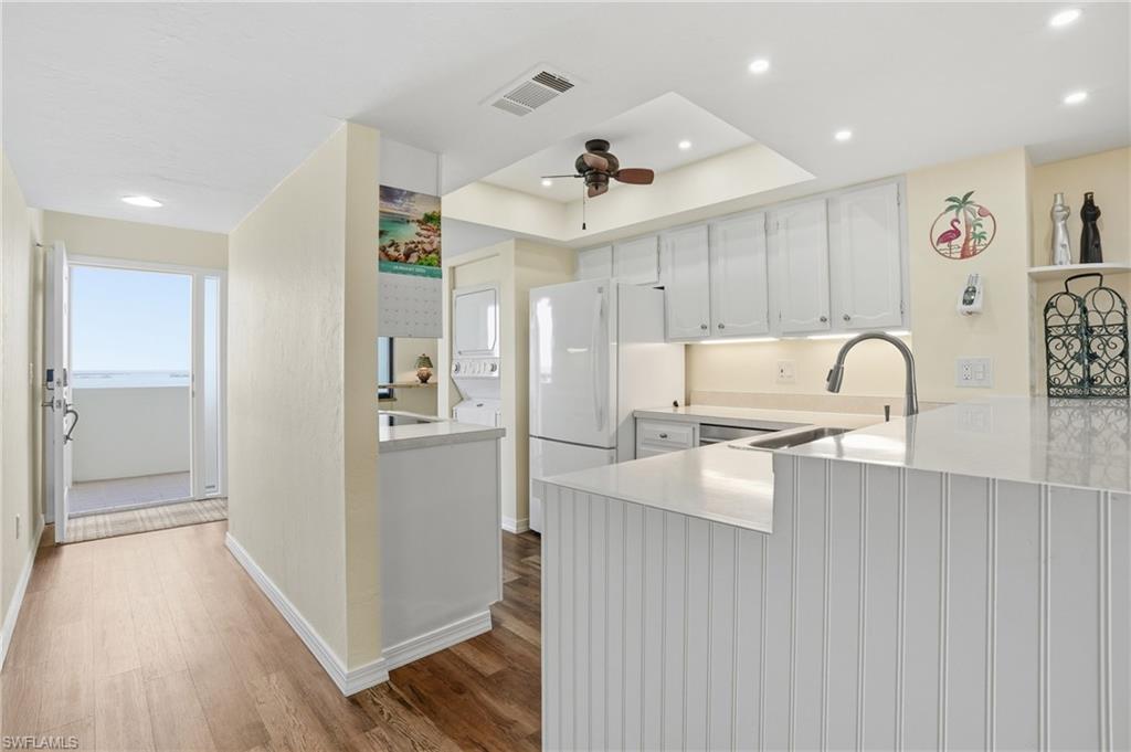Kitchen with recessed lighting with 2 seats at breakfast bar  to view Estero Bay right off kitchen space- Virtually Edited Image