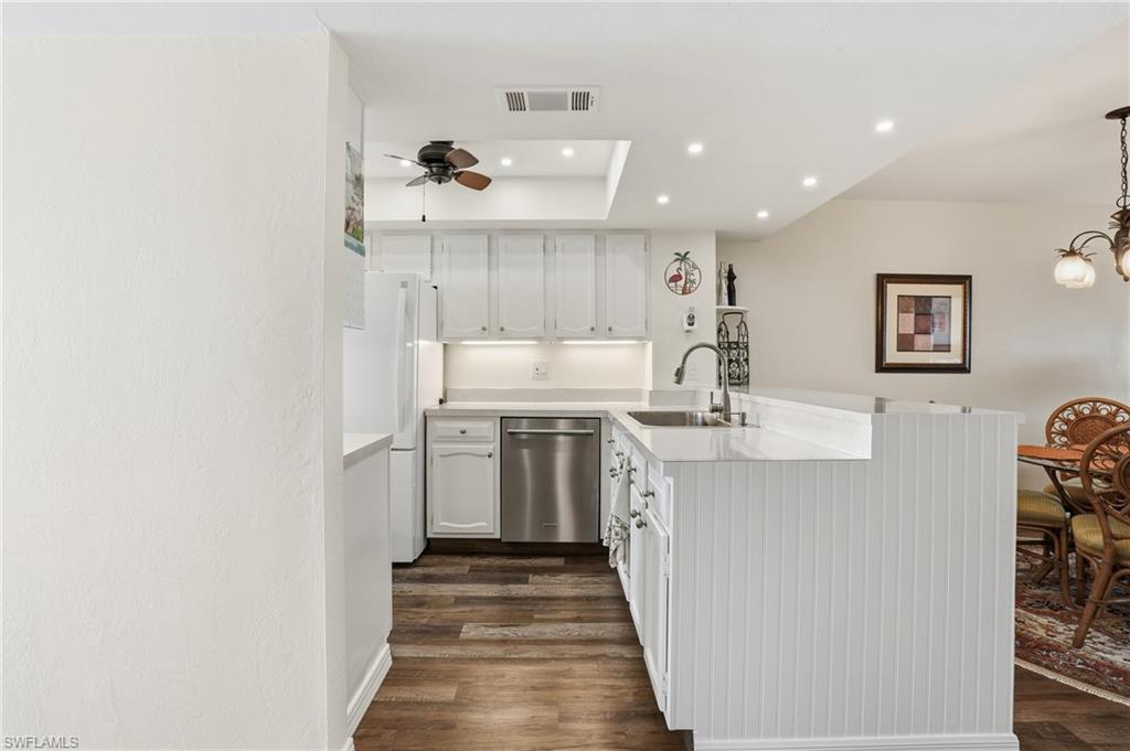 Kitchen with white cabinets, recessed lighting, light countertops, and dishwasher , recessed tray with ceiling fan- Virtually Edited Image