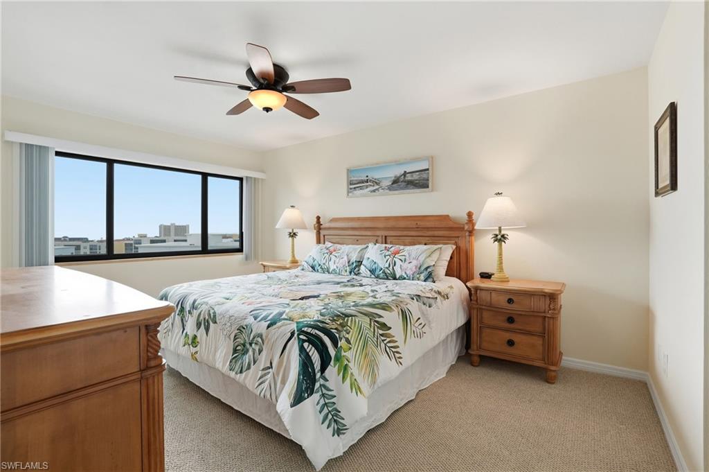 Primary bedroom featuring light carpet and ceiling fan  with beautiful views- Virtually Edited Image