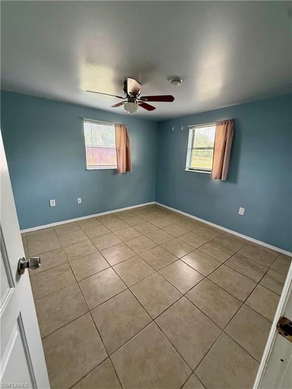 Unfurnished room with plenty of natural light, tile patterned floors, and a ceiling fan