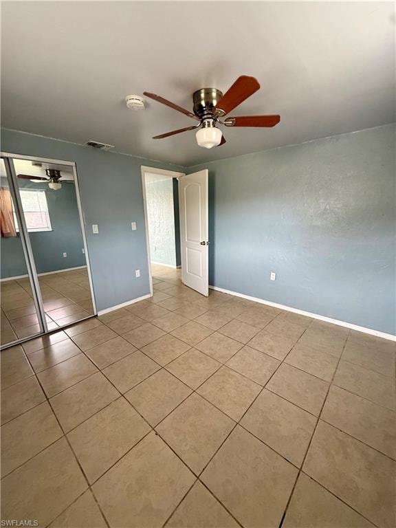 Unfurnished bedroom with a closet, ceiling fan, and tile patterned floors