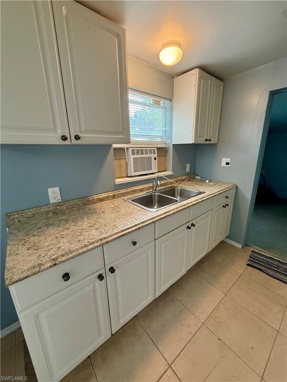 Kitchen featuring white cabinets, light tile patterned floors, and cooling unit