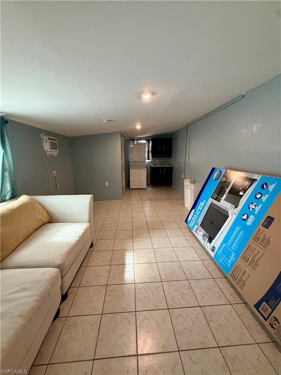 Living room featuring light tile patterned floors and an AC wall unit
