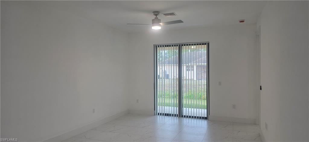 Empty room with light marble finish flooring and ceiling fan