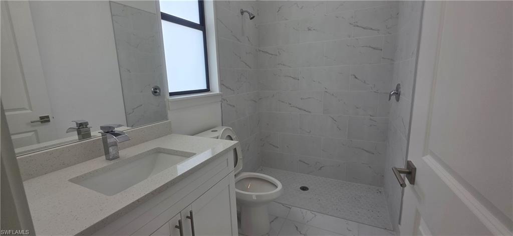 Bathroom featuring vanity, a stall shower, and light marble finish flooring