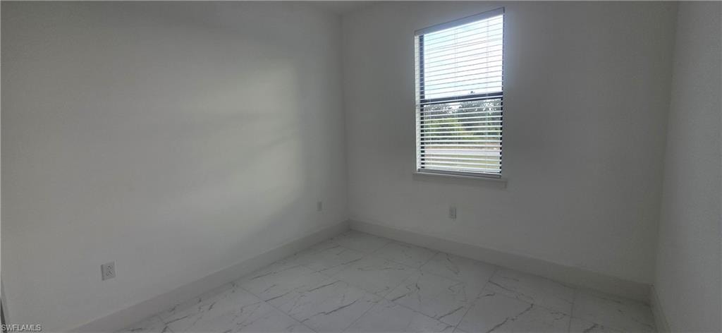 Spare room with light marble finish floors and baseboards