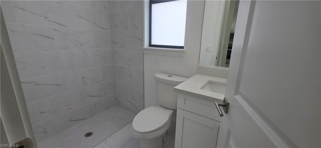 Full bathroom featuring vanity, a shower stall, and light marble finish floors