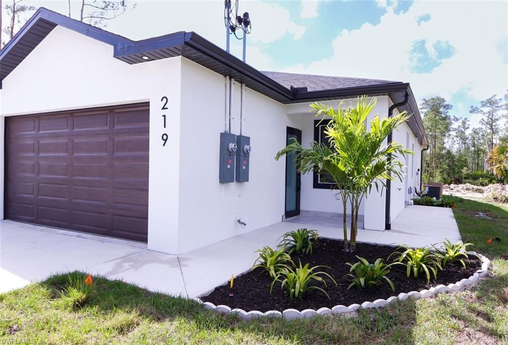 View of side of property with stucco siding and a garage