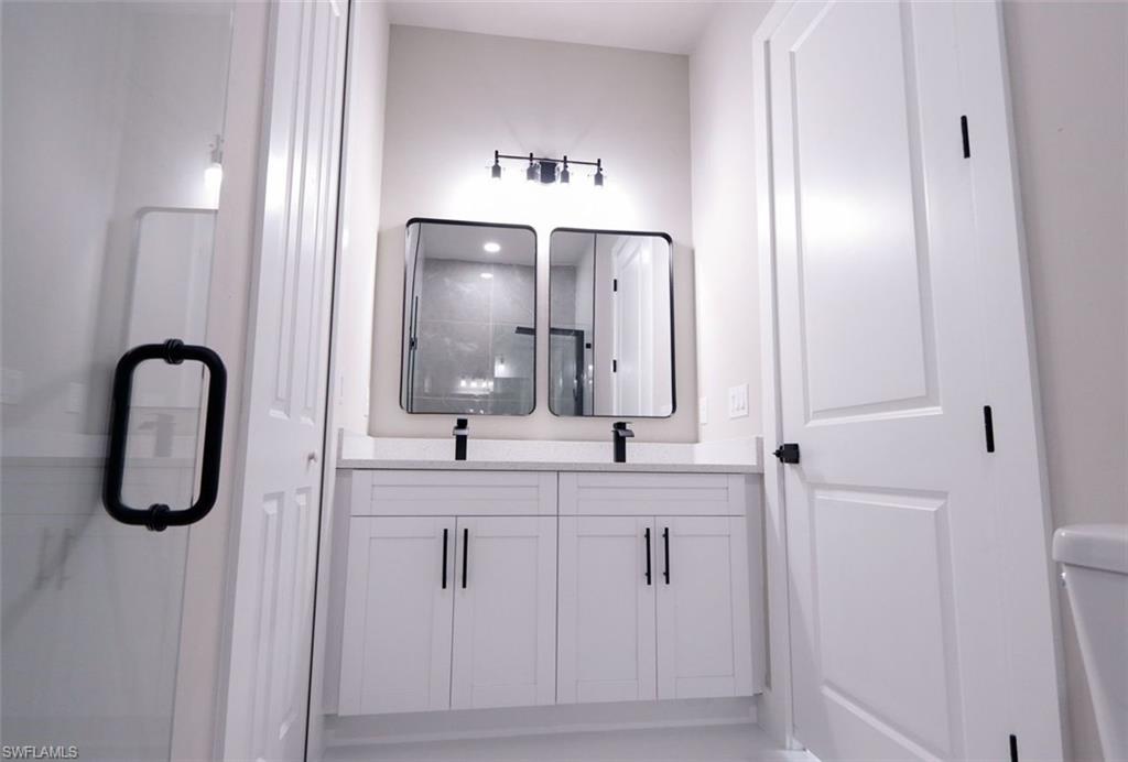 Bathroom featuring double vanity and a stall shower