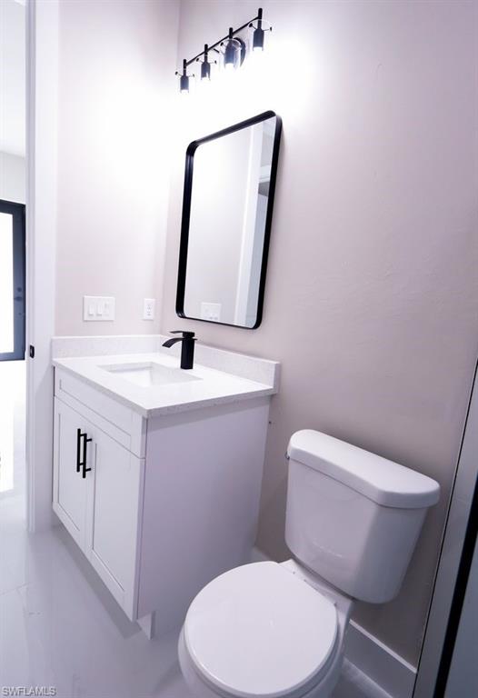 Half bathroom with vanity and light marble finish floors