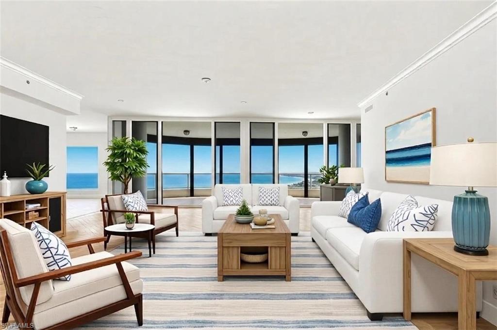 VIRTUALLY STAGED. Spacious living area featuring expansive windows, wood-finish flooring, recessed lighting, crown molding, and a built-in entertainment console