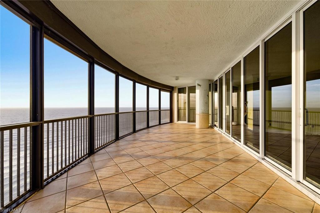 Expansive curved balcony featuring tile flooring and a black metal railing