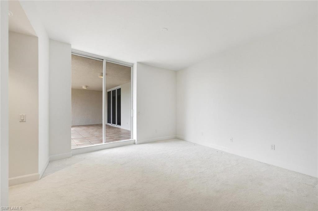 Neutral carpeted room featuring a full wall of mirrored sliding closet doors