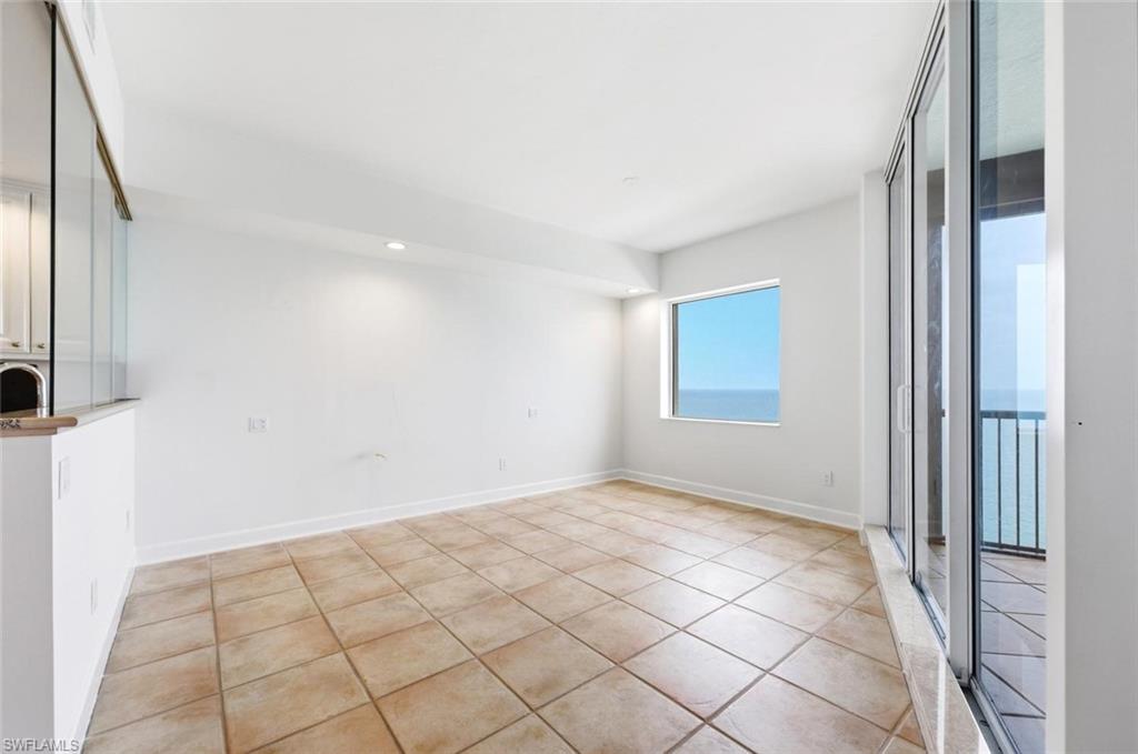 Spacious room featuring tile flooring, white baseboards, and bright white walls