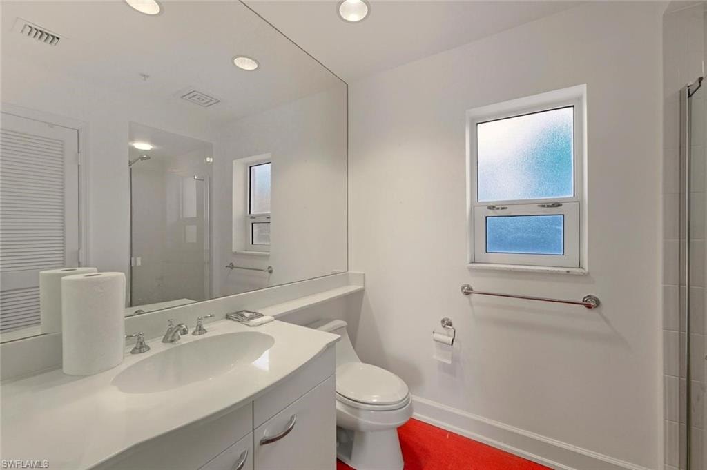 Bathroom featuring a white vanity with an integrated sink, polished chrome faucet, and a large wall-mounted mirror