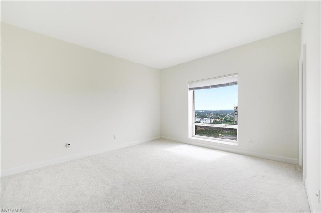 Bright interior featuring a prominent window, white carpeting, white walls, and white trim