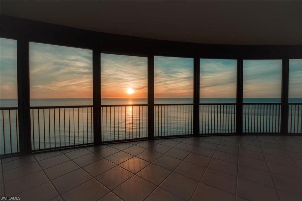 Curved wall of floor-to-ceiling windows overlooking the ocean
