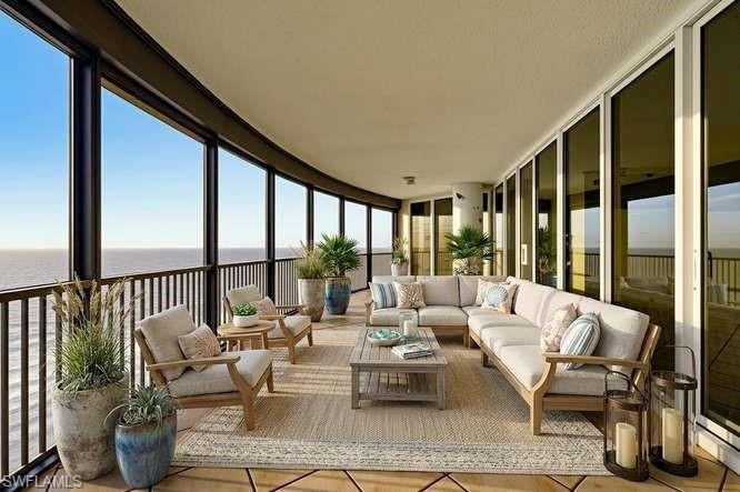 VIRTUALLY STAGED. Expansive curved balcony featuring floor-to-ceiling windows, black metal railings, and a textured ceiling