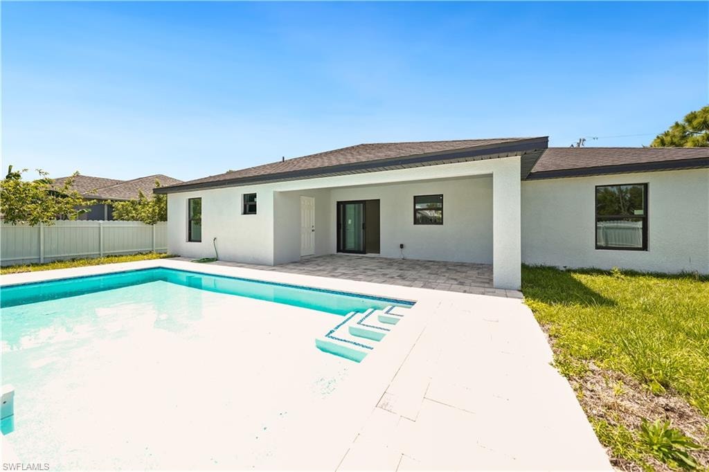 The property features an outdoor swimming pool with steps, surrounded by a paved patio area