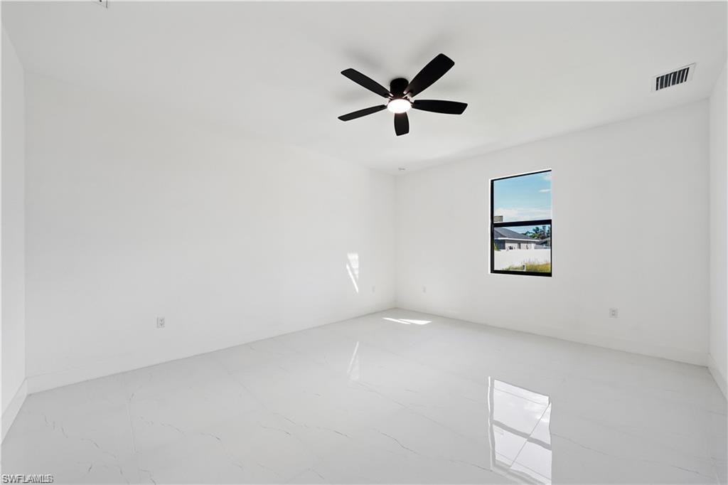 Spare room with a ceiling fan and marble finish flooring