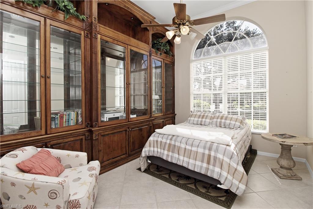 Bedroom with multiple windows, light tile patterned flooring, a ceiling fan, and ornamental molding